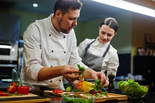 chef teaching student in kitchen